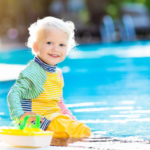 Kleinkind am Pool spielt und lächelt