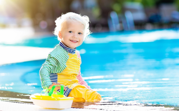 Kleinkind am Pool spielt und lächelt