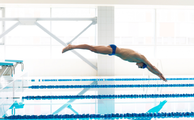 Schwimmer während der Flugphase des Startsprunges