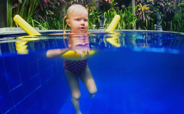 kleines Mädchen schwimmt auf Poolnoodle