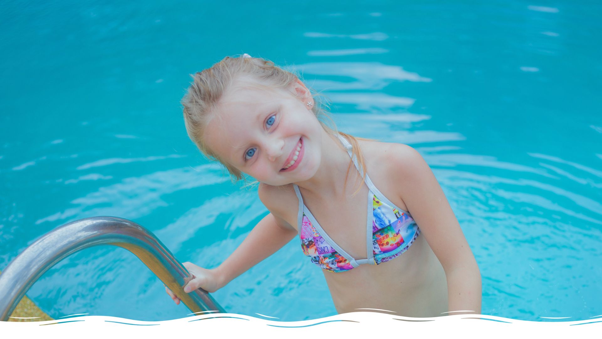 Mädchen am Pool schaut direkt in die Kamera und lächelt